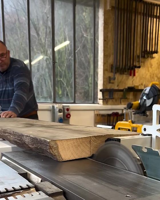 Taglio di una tavola di legno grezzo in falegnameria